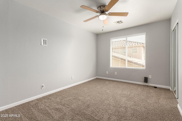 carpeted spare room with a ceiling fan, baseboards, and visible vents
