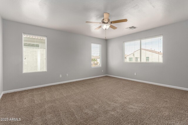 empty room featuring baseboards, carpet flooring, visible vents, and a ceiling fan
