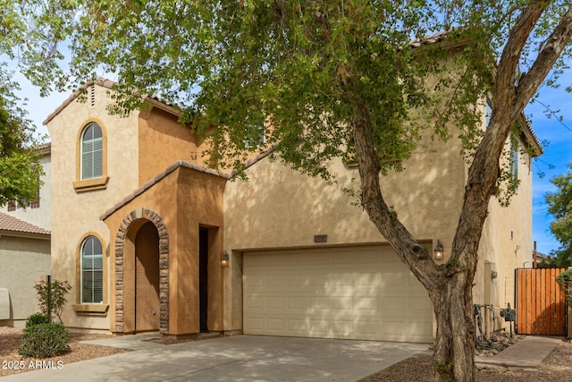 view of front of house with fence, driveway, stucco siding, and a garage