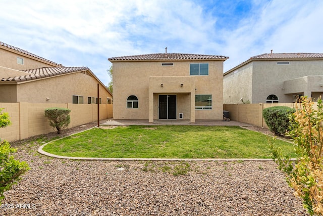 back of house with stucco siding, a fenced backyard, a yard, and a patio area