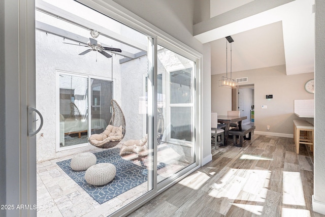 interior space with ceiling fan with notable chandelier and visible vents