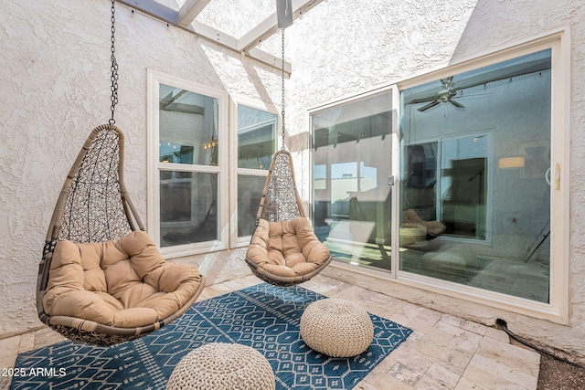 sunroom / solarium with a skylight and a ceiling fan