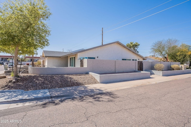 view of front facade with a fenced front yard and stucco siding