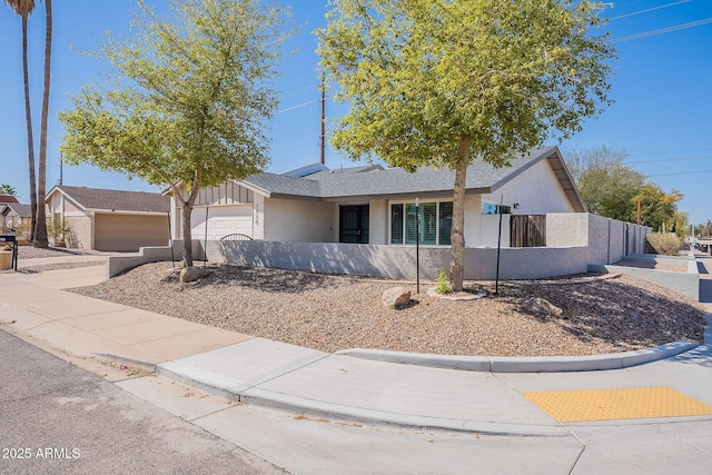 ranch-style house featuring stucco siding, driveway, a garage, and fence