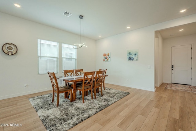 dining area with a notable chandelier and light hardwood / wood-style flooring