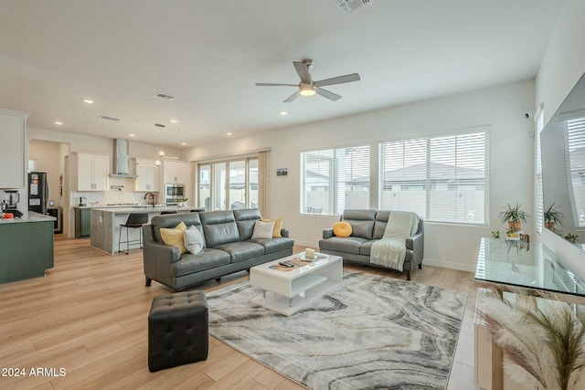 living room with light hardwood / wood-style floors and ceiling fan