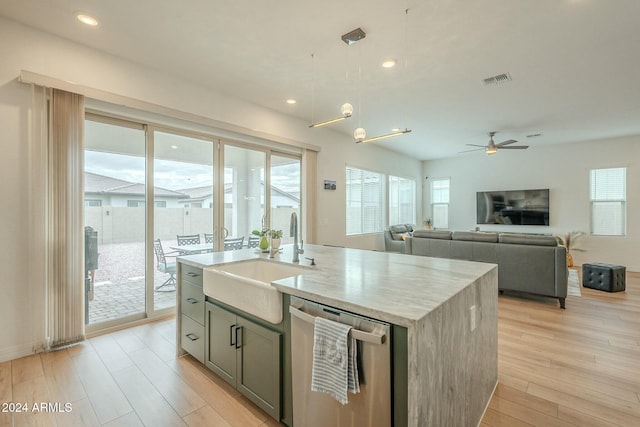 kitchen featuring a center island with sink, stainless steel dishwasher, a wealth of natural light, and sink