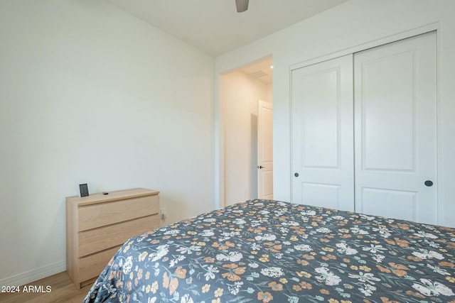 bedroom featuring ceiling fan, a closet, and hardwood / wood-style flooring