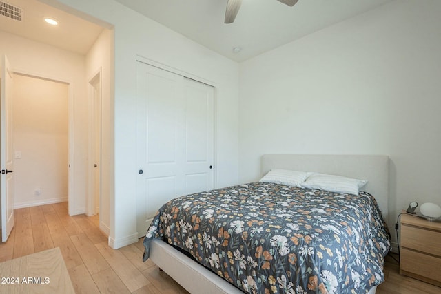 bedroom featuring light hardwood / wood-style floors, a closet, and ceiling fan