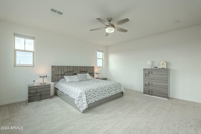 carpeted bedroom featuring multiple windows and ceiling fan