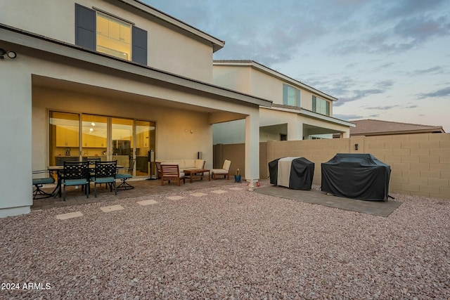 back of house with an outdoor living space and a patio area