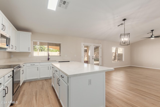 kitchen featuring black range with electric stovetop, white cabinets, sink, light hardwood / wood-style flooring, and a center island