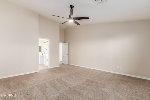 carpeted spare room featuring high vaulted ceiling and ceiling fan