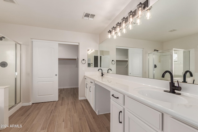 bathroom with vanity, hardwood / wood-style floors, and a shower with door