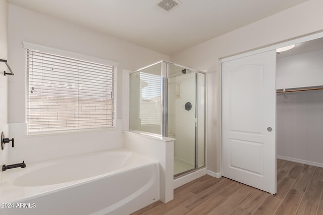 bathroom featuring hardwood / wood-style flooring and separate shower and tub