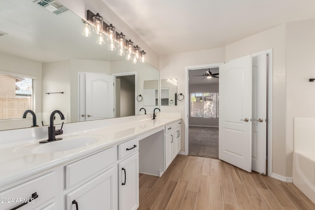 bathroom with a washtub, hardwood / wood-style flooring, vanity, and ceiling fan