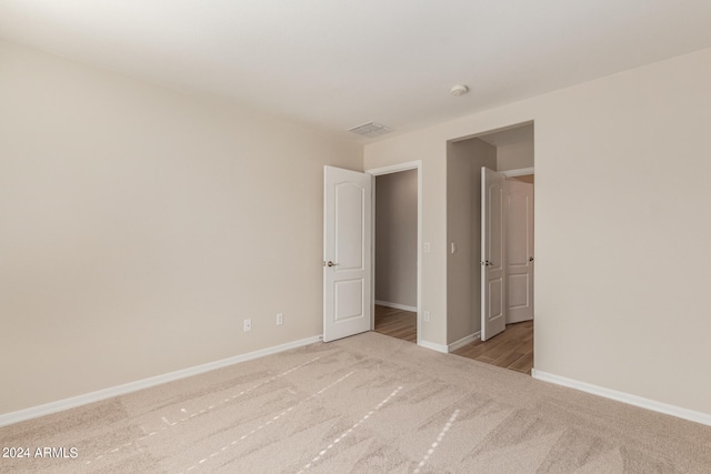 unfurnished bedroom featuring light carpet