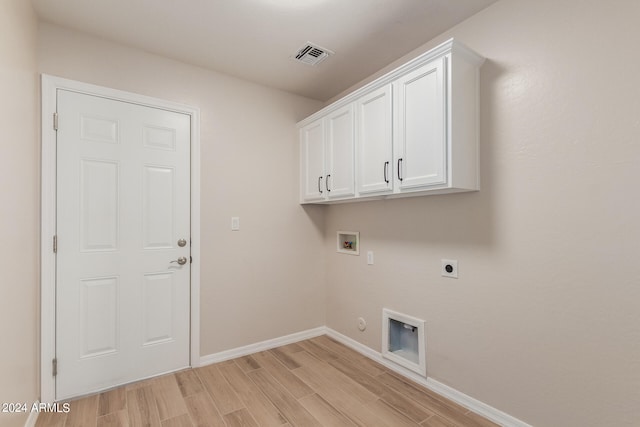 laundry area with hookup for a washing machine, hookup for an electric dryer, light hardwood / wood-style flooring, gas dryer hookup, and cabinets