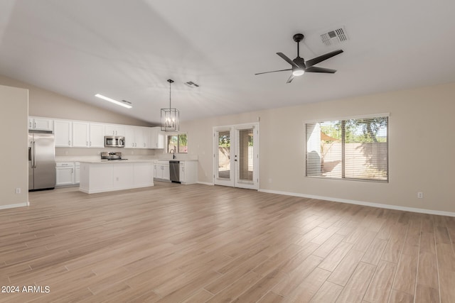 unfurnished living room featuring ceiling fan with notable chandelier, vaulted ceiling, light hardwood / wood-style flooring, and sink