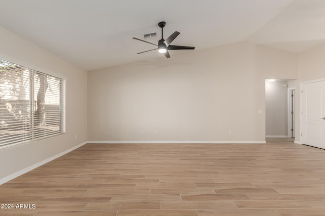 empty room with lofted ceiling, ceiling fan, and light hardwood / wood-style floors