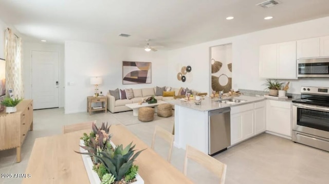12438 E Verbina Ln, Florence, AZ 85132 - kitchen with appliances with stainless steel finishes, white cabinets, a peninsula, recessed lighting, and open floor plan