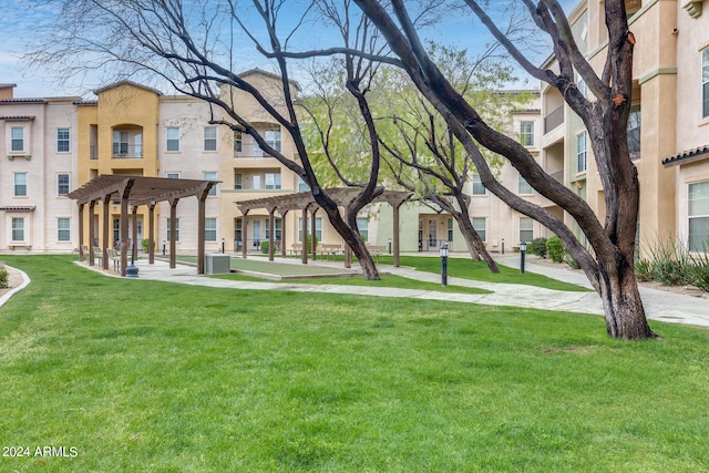 view of home's community with a pergola and a lawn