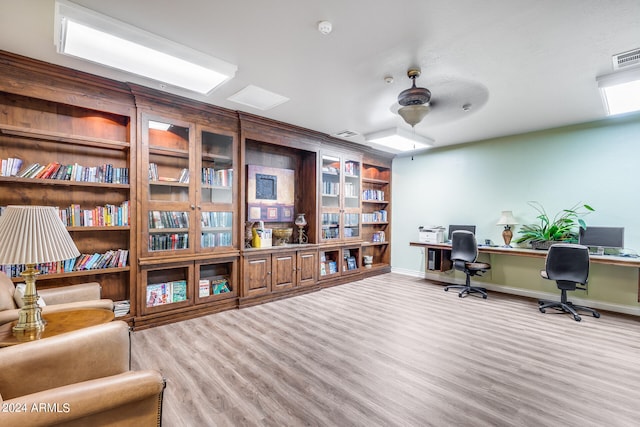 home office with hardwood / wood-style floors, built in desk, and ceiling fan