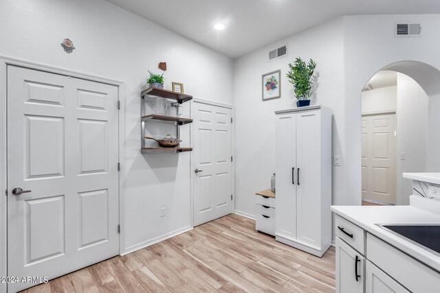 interior space with white cabinetry and light hardwood / wood-style flooring