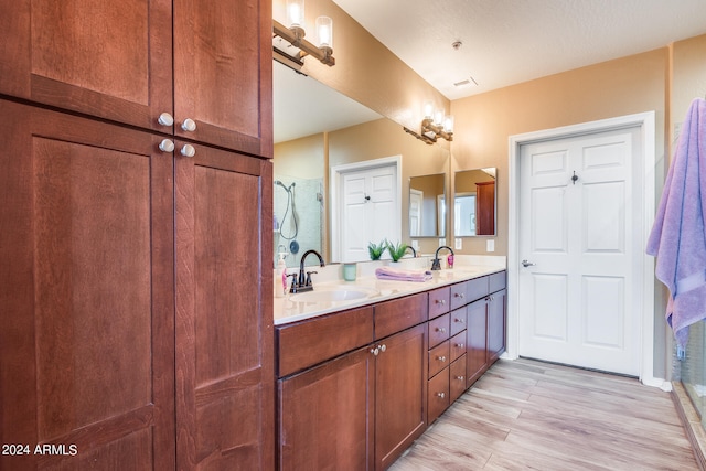 bathroom with hardwood / wood-style floors, vanity, and walk in shower