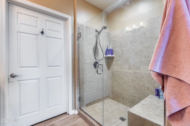 bathroom featuring a shower with door and hardwood / wood-style flooring