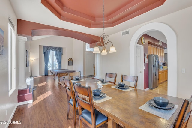 2642 S Joplin, Mesa, AZ 85209 - dining room featuring arched walkways, light wood finished floors, a raised ceiling, decorative columns, and a chandelier