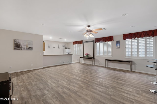 unfurnished living room with hardwood / wood-style flooring and ceiling fan