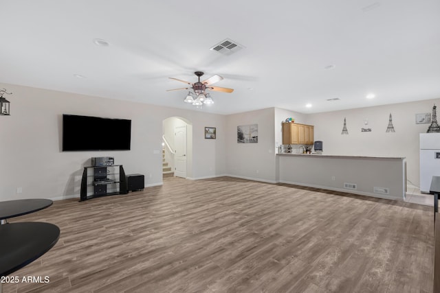 living room featuring ceiling fan and light hardwood / wood-style floors