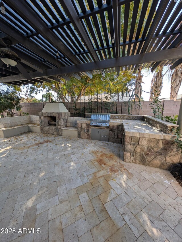 view of patio featuring a pergola, an outdoor kitchen, an outdoor stone fireplace, and grilling area