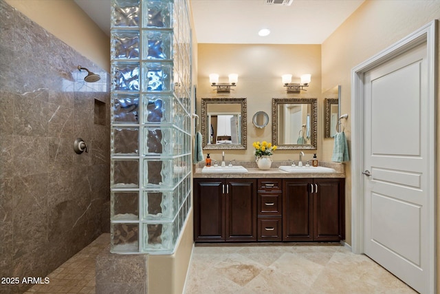 full bathroom featuring double vanity, a sink, walk in shower, and visible vents