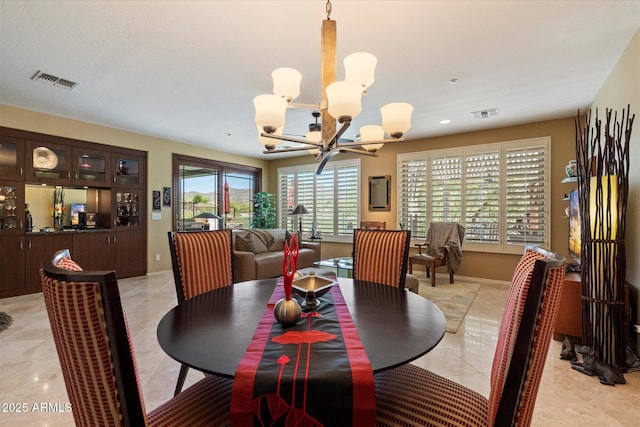 dining area featuring light tile patterned flooring, an inviting chandelier, and visible vents