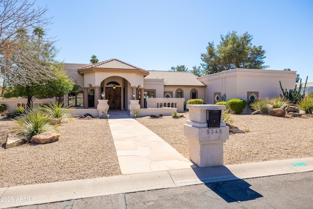 mediterranean / spanish-style home featuring a tile roof and stucco siding