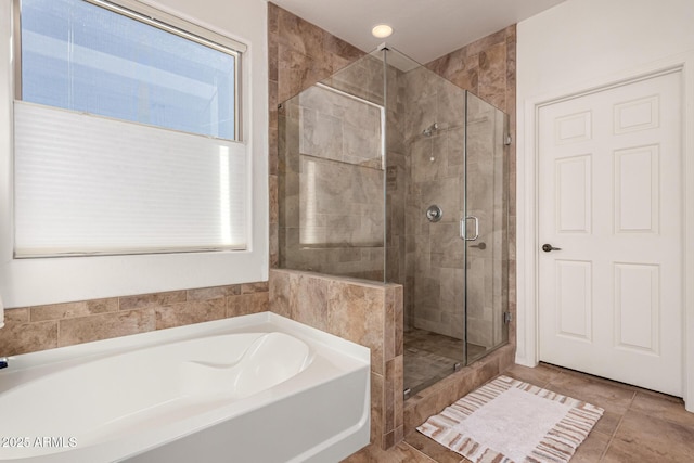 full bathroom featuring tile patterned flooring, a shower stall, and a garden tub