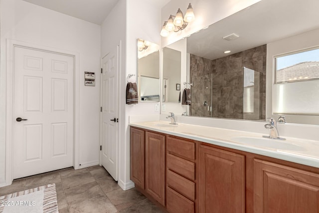 full bathroom with double vanity, tiled shower, and a sink