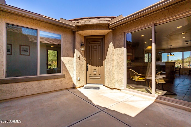 doorway to property featuring a patio and stucco siding