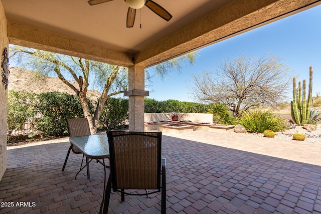 view of patio with a ceiling fan and an outdoor fire pit