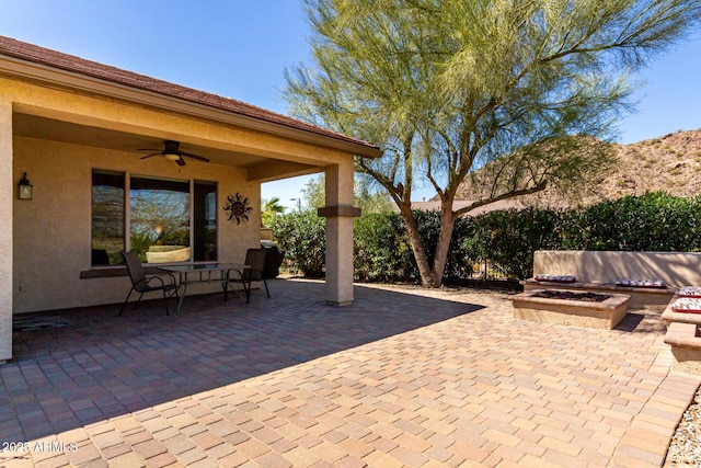 view of patio / terrace with a fire pit and ceiling fan