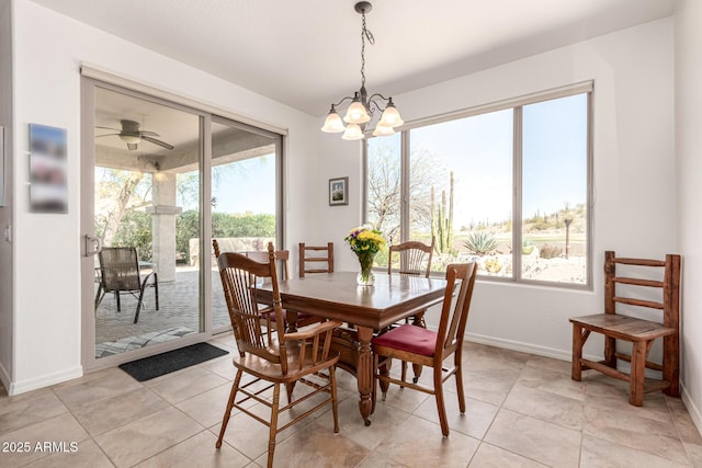 dining area featuring baseboards, a healthy amount of sunlight, light tile patterned flooring, and ceiling fan with notable chandelier