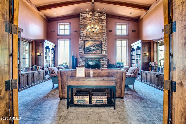 living area featuring beamed ceiling, high vaulted ceiling, a stone fireplace, and a healthy amount of sunlight