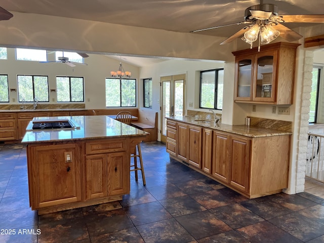 2160 S Moonlight Dr, Star Valley, AZ 85541 - kitchen with stainless steel gas cooktop, a ceiling fan, a breakfast bar, lofted ceiling, and glass insert cabinets