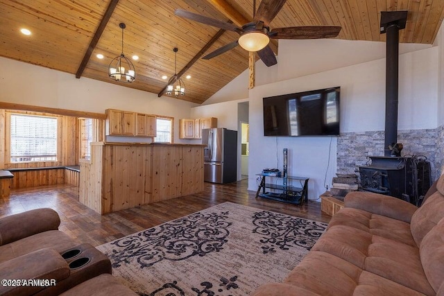 24 N County Road N3101, Vernon, AZ 85940 - living area featuring dark wood finished floors, a wood stove, a ceiling fan, beam ceiling, and wood ceiling