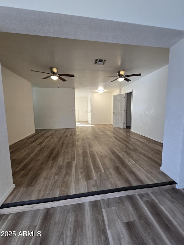 unfurnished living room with ceiling fan and dark hardwood / wood-style flooring