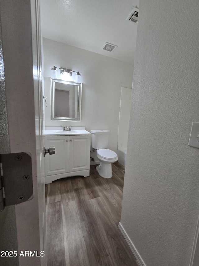 bathroom with vanity, wood-type flooring, and toilet