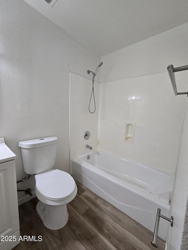 full bathroom featuring hardwood / wood-style floors, vanity, toilet, and shower / bath combination