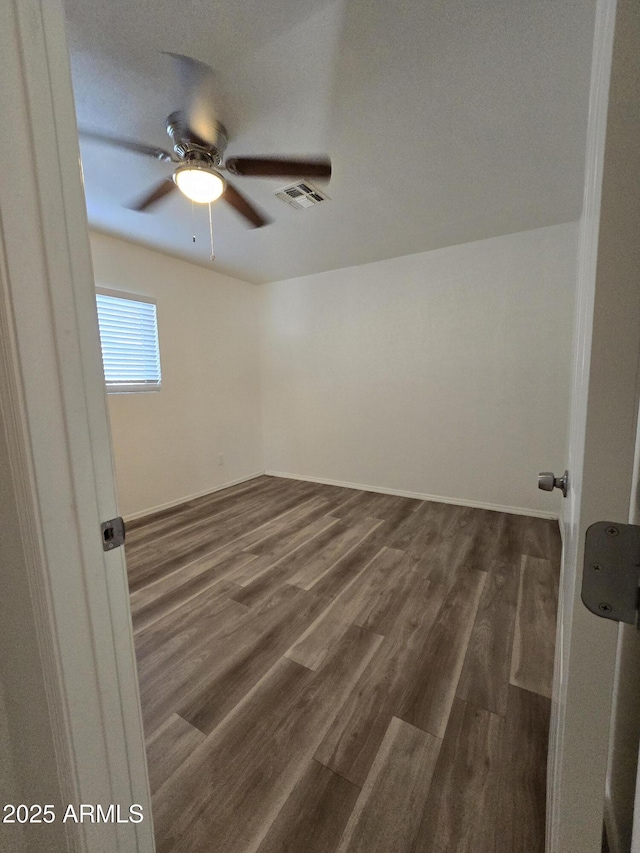 spare room featuring dark hardwood / wood-style floors and ceiling fan